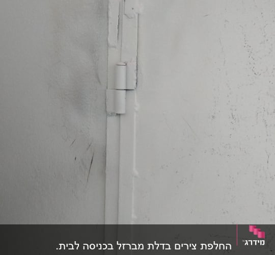 ציר דלת מתכת לבנה עם סימני שחיקה